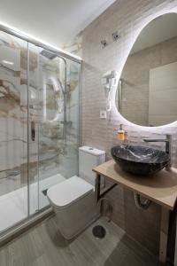 a bathroom with a sink and a toilet and a shower at Rosales Suites in Madrid +19 photos