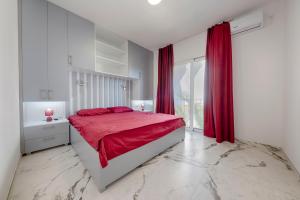 a bedroom with a red bed and a large window at MEMO's DUKAT in Šušanj