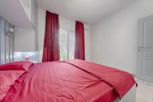 a bedroom with a red bed and a window at MEMO's DUKAT in Šušanj