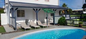 a swimming pool in front of a house at Hébergement T3 COSY WOUSIRE in Les Abymes
