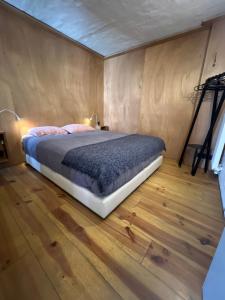 a bedroom with a bed and a wooden floor at Studio 17 in Ghent