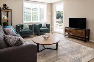 a living room with a couch and a tv at Pool-View condo at Pinnacle Pointe Resort-Sleeps 6 in Kelowna