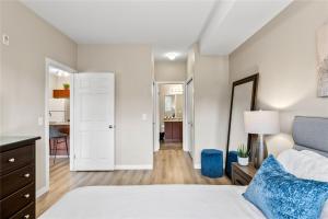 a bedroom with a bed and a hallway with a desk at Pool-View condo at Pinnacle Pointe Resort-Sleeps 6 in Kelowna