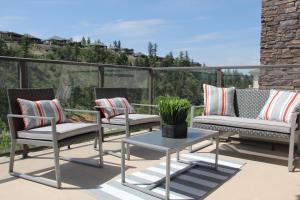 a patio with two chairs and a table on a balcony at Pool-View condo at Pinnacle Pointe Resort-Sleeps 6 in Kelowna