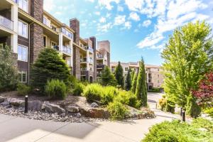 an apartment complex with a garden in front of a building at Pool-View condo at Pinnacle Pointe Resort-Sleeps 6 in Kelowna +25 photos