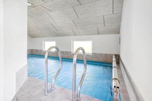 a swimming pool with two metal hand rails next to it at FY132-Middelfart-Stjernevej-109 in Middelfart