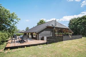 a small house with a wooden deck in a field at FY132-Middelfart-Stjernevej-109 in Middelfart