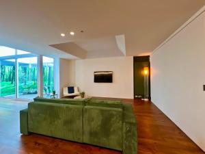 a living room with a green couch and a tv at Studio 17 in Ghent