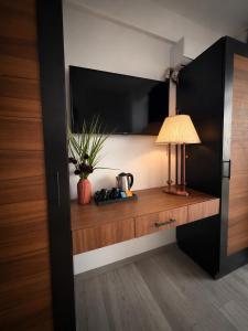 a room with a desk with a lamp and a tv at Hotel Amur in Corbu