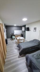 a room with two beds and a table in it at Hermosos monoambientes a estrenar in Comodoro Rivadavia