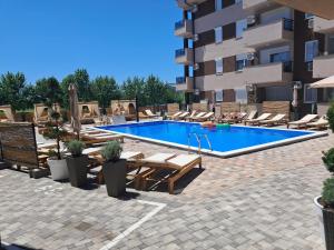 a swimming pool with lounge chairs and a hotel at Harmony Srebrno jezero in Veliko Gradište