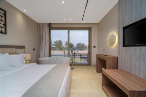 a bedroom with a bed and a tub and a television at Koun Pyramids Hotel in Cairo +78 photos