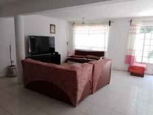 a living room with a couch and a tv at EL Jardin De Los Anturios in Xico +25 photos