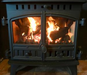 a fireplace with meat cooking in it at Tornaroan Cottage in Ballycastle +110 photos