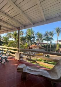 a bench on a patio with palm trees in the background at Wind & Sun Kite Pousada in Canoa Quebrada