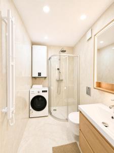 a bathroom with a shower and a washing machine at Express Guest House in Klaipėda +23 photos