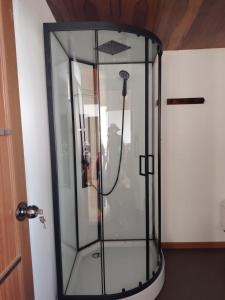 a shower with a glass door in a room at Titicaca Magical Lodge Peru in Puno