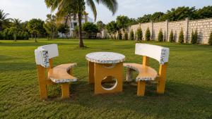 three chairs and a table in a park at Harlequin Diani in Diani Beach