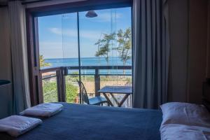 a bedroom with a bed and a view of the ocean at Pousada Pontal RJ in Rio de Janeiro +21 photos