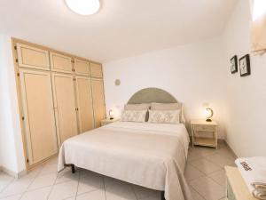 a bedroom with a large bed and a large cabinet at Sardinia Re - Grecale 25 in Porto Rotondo +5 photos