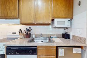 a kitchen with a sink and a microwave at Second-floor condo with 2 shared pools hot tub sauna in South Lake Tahoe