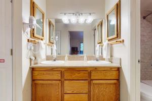 a bathroom with two sinks and a large mirror at Second-floor condo with 2 shared pools hot tub sauna in South Lake Tahoe