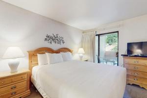 a bedroom with a large white bed and a television at Second-floor condo with 2 shared pools hot tub sauna in South Lake Tahoe