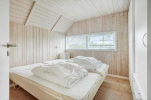 a bedroom with a bed with white sheets and a window at FY244-Assens-Osterbakken-3 in Assens