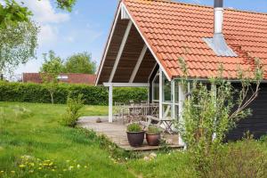 a wooden deck with a house with a red roof at FY244-Assens-Osterbakken-3 in Assens