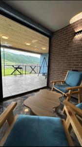 a room with two chairs and a table and a large window at Shahdag Berghoff Villas in Qusar +71 photos