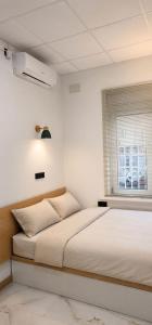 a white bedroom with a bed and a window at Aloha Beach Apartament Con Baño privado in Alicante