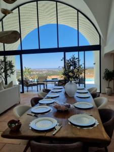 a wooden table with plates on it in a room with a large window at Dar El Monchar - Hammamet in Hammamet