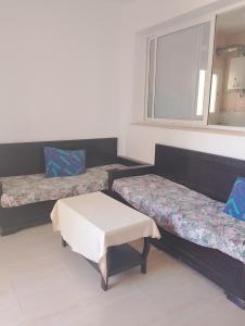 a room with two beds and a window at Morgan Appartements in Hammam Sousse +3 photos