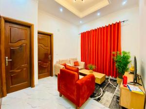 a living room with a red curtain and a couch at Résidence moncloa in Brazzaville