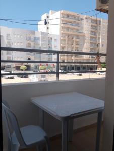 a table and a chair in front of a window at Morgan Appartements in Hammam Sousse
