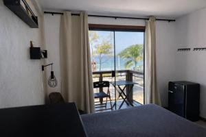 a bedroom with a bed and a view of a balcony at Pousada Pontal RJ in Rio de Janeiro