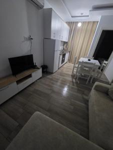 a living room with a couch and a kitchen with a table at Solei Sea Apartment in Shëngjin