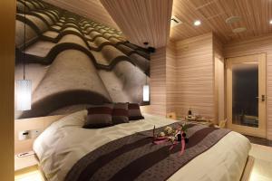 a bedroom with a large bed with a painting on the wall at ホテル ゼン町田 in Machida