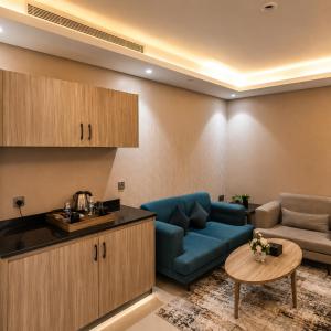 a living room with a blue couch and a table at Medhal Hotel in Jeddah