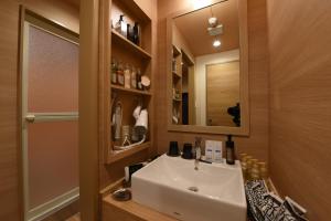 a bathroom with a white sink and a mirror at ホテル ゼン町田 in Machida +18 photos