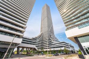 a view of a tall skyscraper between two buildings at Waterfront Luxury Condo in Toronto