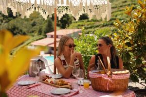 two women sitting at a table with a plate of food at Private Douro- Quinta das Susandas in Mesão Frio