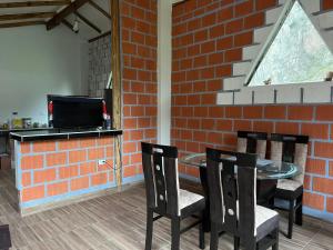 a room with a table and chairs and a brick wall at Sky Domos Pachar in Pachar