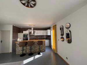 a kitchen with a counter and some chairs in it at Bel Appartement Perrières in Brive-la-Gaillarde +14 photos