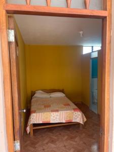 a bedroom with a bed in a yellow wall at Pacasmagic Surf&Kite in Pacasmayo