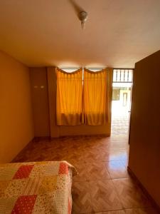 a bedroom with yellow curtains and a bed in a room at Pacasmagic Surf&Kite in Pacasmayo