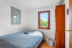 a bedroom with a blue bed and a window at FY267-Faaborg-Horsehoved-37 in Faaborg