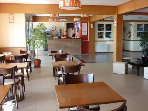 a dining room with tables and chairs in a restaurant at Marcopolo Suites Calafate in El Calafate