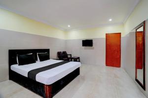a bedroom with a bed and a flat screen tv at Hotel O Meera in Chennai