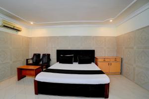 a bedroom with a bed and a table and chairs at Hotel O Meera in Chennai +61 photos